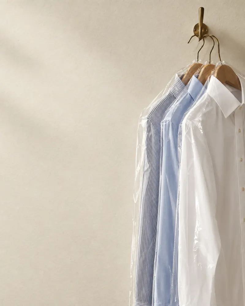 Ilustración de tres camisas colgadas en ganchos de madera
